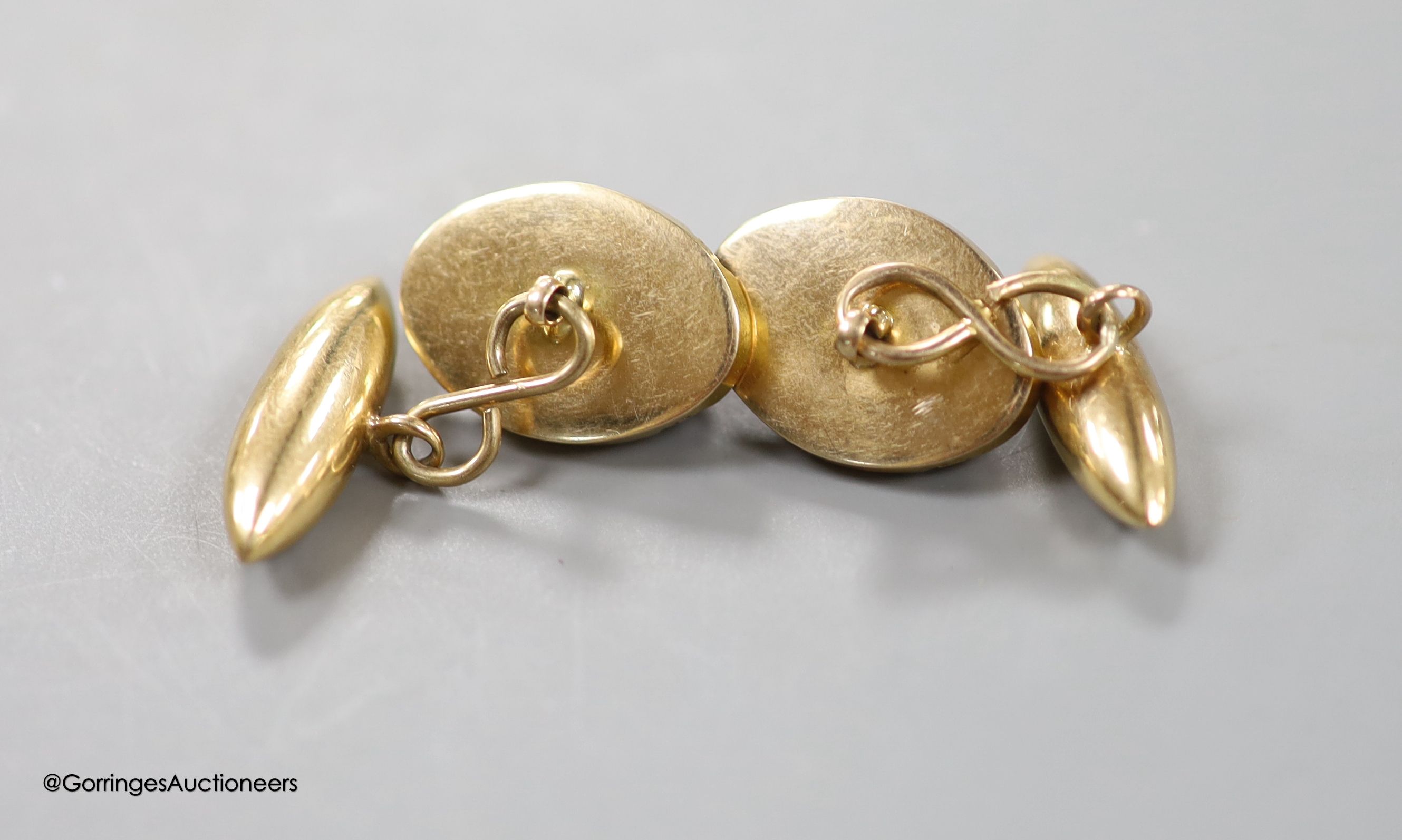 A pair of yellow metal and cabochon garnet set oval cufflinks, 18mm, gross weight 10.7 grams.